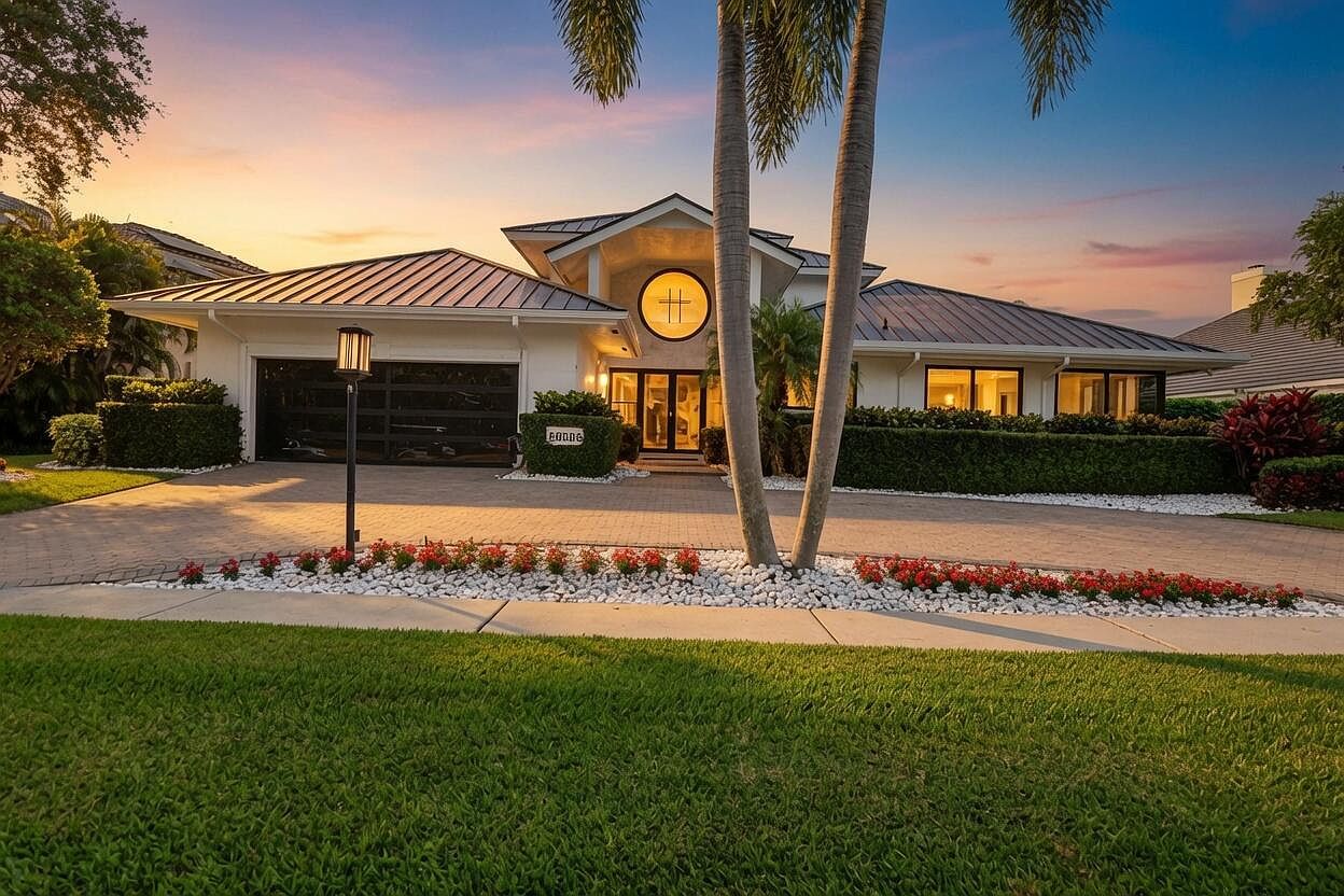 Front of 21312 Greenwood Ct at twilight, with the lit two-story entry, tall palms and a manicured front lawn