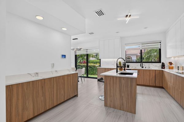 Kitchen overview with the long walnut island and windows to the garden