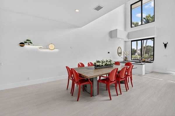 Dining area with red chairs under the double-height ceiling