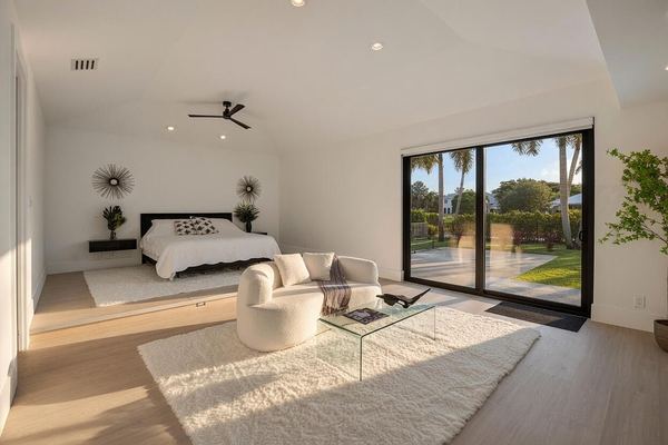Primary bedroom with a platform bed, a glass coffee table and sliding doors to the pool
