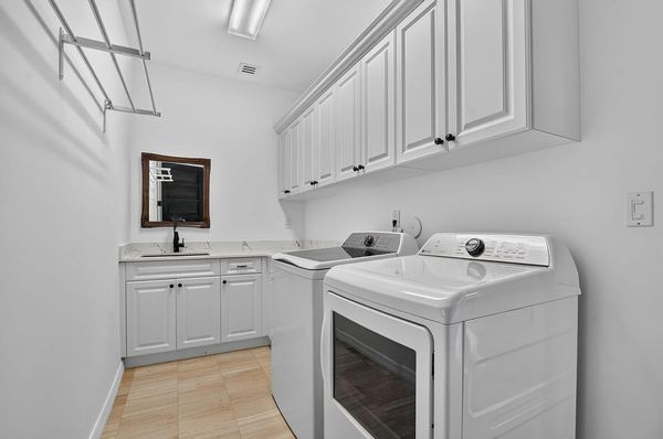 Laundry room with white cabinets and a front-load washer and dryer