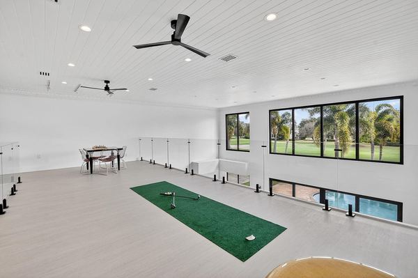 Large second-floor loft with a putting green and a wall of windows, with room to expand