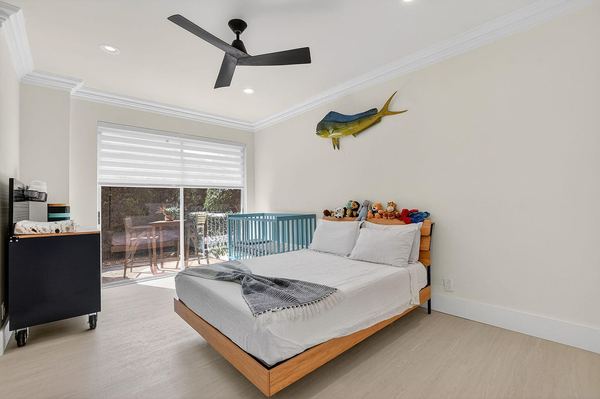 Bedroom with a wood bed frame, a ceiling fan and sliding doors