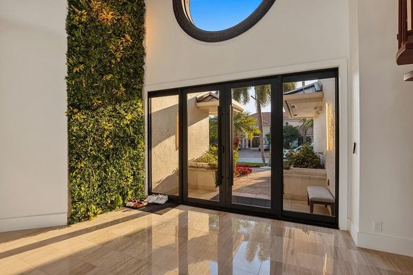 Foyer with a living green wall, a round window and glass entry doors