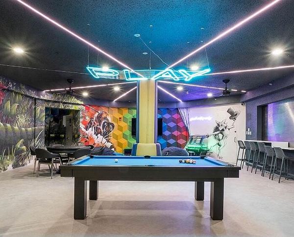 Club game room with a pool table and neon lighting